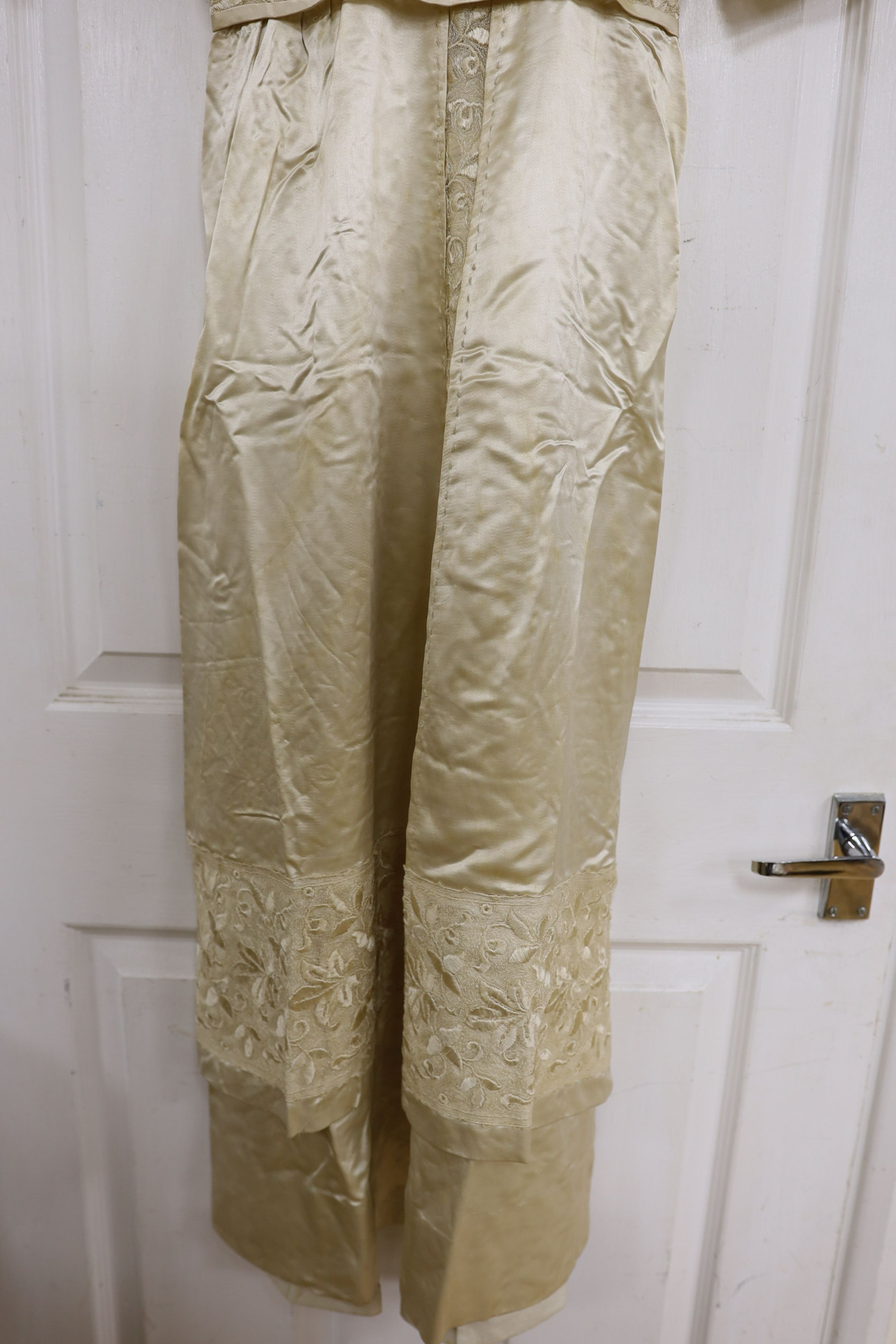 An Edwardian cream satin lady's dress with embroidered panels to base,sleeves front and collar